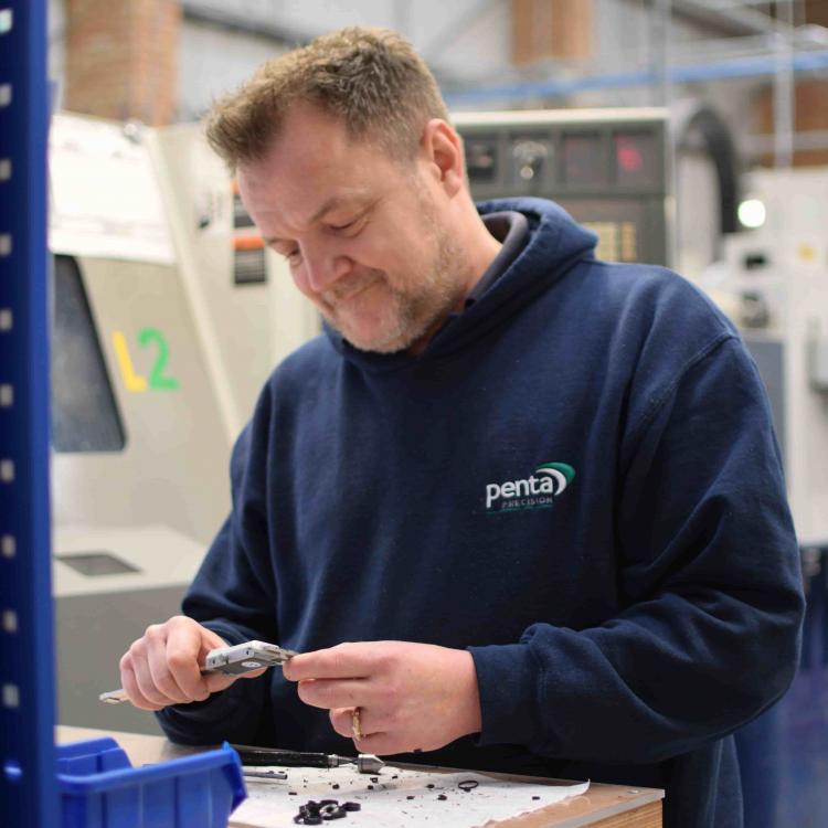 Machinist using Vernier calipers